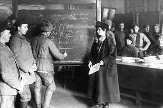 An early post-revolution classroom where adults are being taught to read, write, and do arithmatic, 1920s.