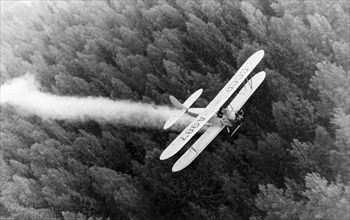 A polikarpov po-2 (u-2) biplane spraying pesticides over forests, late 1940s.
