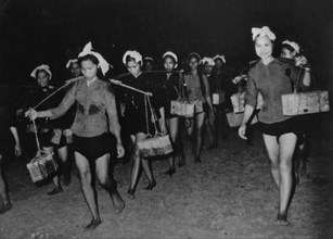 A women's unit carrying supplies to the south vietnam people's liberation army forces along the ho chi minh trail at night, vietnam war, 1968.