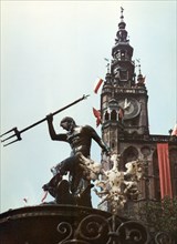 Neptune fountain and the city hall clock tower in gdansk, poland, 1965.