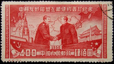Chinese postage stamp commemorating the execution of the sino-soviet treaty of friendship in 1950, joseph stalin and mao zedong are shaking hands.