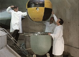 The descent capsule of soviet space probe venera 5 or 6 being lowered into a centrifuge for testing, this is a still from the film 'the storming of venus', produced by e, kuzis at the tsentrnauchfilm ...