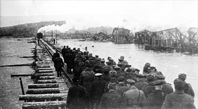 Soviet troops walk on a newly-built railway bridge across the dnieper river during the world war ll, the old bridge was destroyed by nazi air raids.