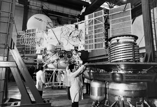 Technicians working on the assembly of the soviet space probe vega at the baikonur cosmdrome, 1984, the venera descent module is in the foreground.
