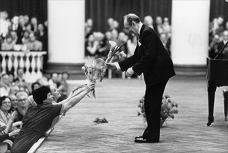 Pianist vladimir horowitz receiving flowers at the end of his concert at the dmitri shostakovich philharmonic society hall in leningrad, ussr, may 1986.