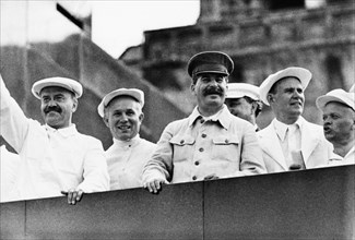 Vyacheslav molotov (left), nikita khrushchev, and joseph stalin on the rostrum of the v,i, lenin mausoleum in red square, watching an athletic parade in 1936.