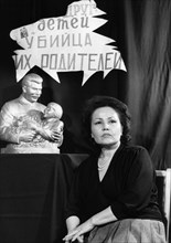 Engelsina cheshkova (gelya markizova) at a conference in 1990, behind her is one of the ubiquitous statues from 1936 of her as a 7-year-old with stalin and a sign that reads: 'friend of children, murd...