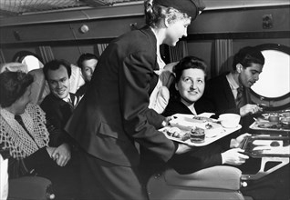 A stewardess serving a meal to passengers aboard a tu-114 airliner (at the time, the world's largest), 1959.