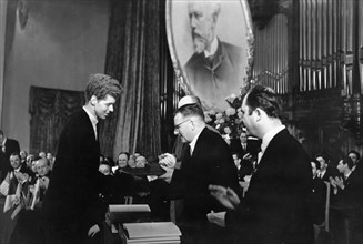 During the closing ceremonies of the tchaikovsky international violin and piano competition, soviet composer d, shostakovich presents a gold medal and a diploma of honor to american pianist van clibur...