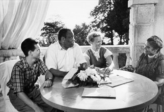Paul robeson and his wife eslanda during a visit to a summer resort in sochi, august 1958,  they are sitting on the veranda of the 'new sochi' sanitorium with their guests adoi korotkevich, a tashkent...