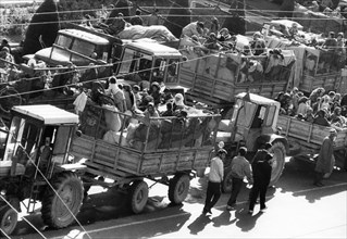 Refugees from the war-torn southern regions of tajikistan arriving in dushanbe by tractors, december 1992.