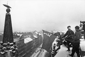 World war 2, soviet soldiers raising the flag of victory above a city building in budapest, hungary after the capture of the hungarian capital, february 1945.