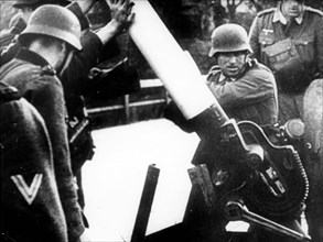German soldiers breaking the wooden road barrier on soviet border in 1941.