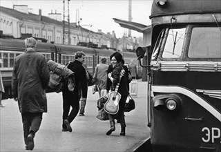 A young russian couple at a moscow train station, leaving the city with rucksack and guitar, vacation, ussr, 1970.
