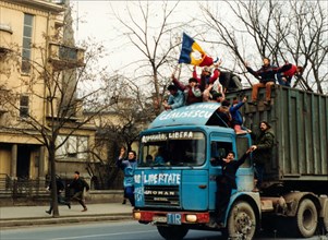 Boys ride on a truck during the revolt in bucharest, romania, december 1989.