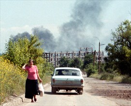 Chechnya, russia, june 16, 2001, peaceful life in grozny borders upon remaines of the war, such as a view of ruins of the chechen gas and oil insitute (on the background), a train of smoke from a burn...