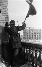 World war 2, battle of stalingrad, february 1943: a red army soldier raises the soviet flag (hammer and sickle) on the roof of a downtown stalingrad depatment store where the staff of field marshal vo...