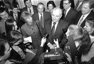 Ex-president of the ussr mikhail gorbachev and his wife raisa talking to journalists during gorbachev's visit to st,petersburg in april 1994, future president of russia, vladimir putin, is standing di...
