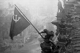 Red army soldiers raising the soviet flag over the reichstag in berlin, germany, april 30, 1945.