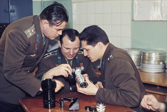 Soviet cosmonauts boris volynov, yuri gagarin, and andrian nikolayev examining a camera, 1968.