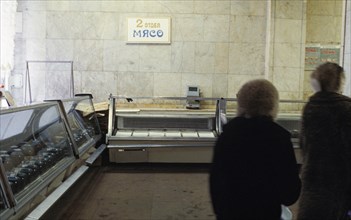 Shoppers walking past an empty meat counter at a grocery store in moscow, the shocking 'liberalization' of prices hasn't added to the availability of goods in moscow shops, january 1992.