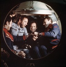 Salyut 6, soyuz 26, soyuz 27, soviet cosmonauts yuri romanenko, georgi grechko, oleg makarov, and vladimir dzhanibekov shaking hands in the module, 1978.