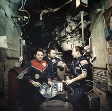 Soviet cosmonauts alexei gubarev, georgi grechko and  vladimir remek performing medical research aboard the salyut 6 space station, soyuz 26 and soyuz 28, 1978.