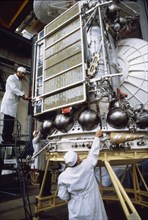 Technicians working on a working mock-up of the soviet venera 15 & 16 space probe during tests, 1983.