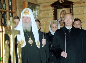 President vladimir putin (right) and the head of the russian orthodox church, patriarch alexy of moscow and all russia attend the funeral service for the victims of the october 25 crash of the il-18 m...