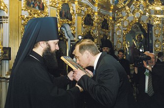 Russian president vladimir putin kissing an icon at the kiev-pechora lavra assumption cathedral during his visit to ukraine, may 2000.