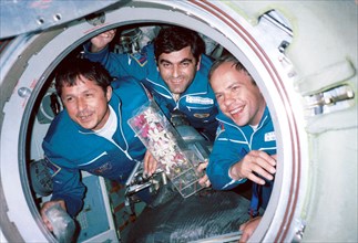 Russian cosmonauts viktor savinykh (left) and anatoly solovyov(right) and bulgarian astronaut alexander alexandrov (centre) seen pictured with orchids in the access hatch of the 'mir' space station, t...