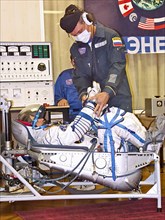 Baikonur, kazakhstan, september 18, 2006, a russian specialist checks the spacesuit of first female space tourist anousheh ansari before the launch of soyuz tma-9 rocket, which spacecraft is to take t...
