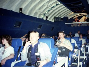 Moscow, russia 8/2000: a group of newsmen enjoy a simulated space flight aboard the buran space shuttle which was re-equipped as an amusement to launch a new entertainment at the gorky recreation park...