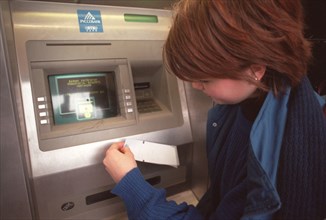 A russian girl at a cash dispenser in novy arbat street downtown moscow, russians who use plastic cards may face difficulties during the new year celebrations as in the days of the holiday all cash di...