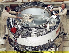 Space rocket research and production centre of the 'tskb - progress' in samara, russia, electricians vladimir mordvinov and vyacheslav makarov pictured mounting a foton spacecraft.