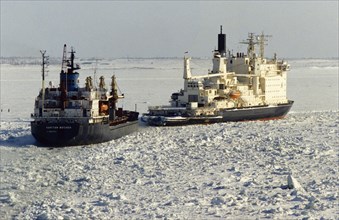 Nuclear powered icebreaker, vaigach, leading a cargo ship out of dudinka harbor into the arctic ocean, russia, 2001.