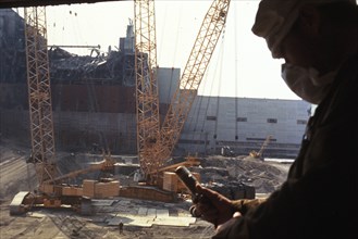 Recording radiation levels during the construction of the sarcophagus containg unit 4 of the chernobyl aps, ukraine, ussr, august 1986.