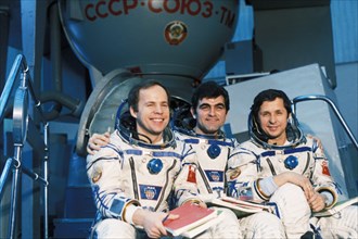 Soyuz tm-5 crew anatoly solovyov, aleksandr panayotov aleksandrov (bulgaria), and viktor savinykh in front of a soyuz simulator during training, 1988.