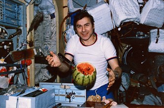 Soyuz tm-3, aleksandr pavlovich aleksandrov cutting a watermelon delivered to the mir space station by progress 31, 1988.