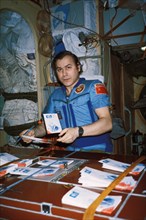 Soyuz tm-3, soviet cosmonaut aleksandr pavlovich aleksandrov sorting mail aboard mir, 1988.