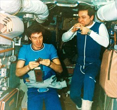 Soyuz tm-7, soviet cosmonauts alexander volkov and sergei krikalev (left) eating lunch aboard the mir space station, 1988.