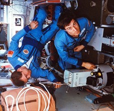 Soyuz tm-7, soviet cosmonauts alexander volkov and sergei krikalev (right) conducting an experiment aboard the mir space station, 1988.