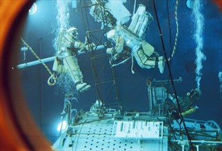 Russian cosmonauts anatoly solovyev and sergei avdeyev with michel tognini (french) training in the hydrochamber of the gagarin training center for the soyuz tm-15 mission, 1992.