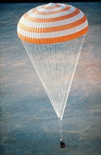 Re-entry capsule of the soyuz t-4 mission to salyut 6 space station parachuting back to earth in 1981.