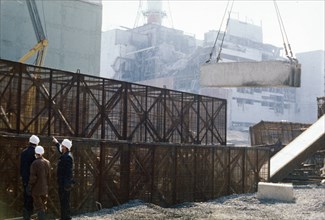 Construction crews building a containment wall around the damaged unit 4 reactor, chernobyl aps, ukraine, ussr, august 1986.