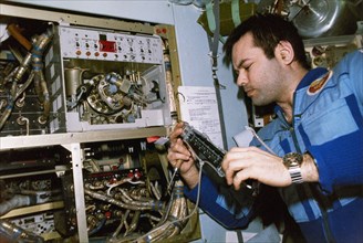 Mir, soyuz tm-2, cosmonaut aleksandr laveykin readies the svetlana elektrophoretic installation in the quantum module of the mir space station, 1987.