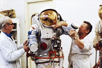 Assemblers at a recently de-classified aerospace facility ivan volchenkov and nikolay petrov with one of several newly designed spacesuits to be delivered to the mir space station, 1992.