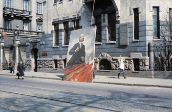 A poster of lenin being put up for may day in leningrad, 1968.