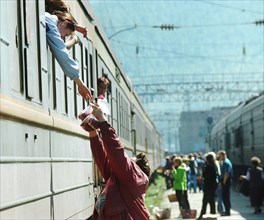 Irkutsk region, russia, october 8, 2003, a woman, resident of the town of slyudyanka, selling berries to passengers on the railway station, such trade is the main way of earning money for people in sl...