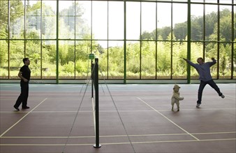 Sochi, russia, august 14, 2009, prime minister of russia vladimir putin and russian president dmitry medvedev (r) play badminton, as medvedev's golden retriever aldo runs around, after a working meeti...